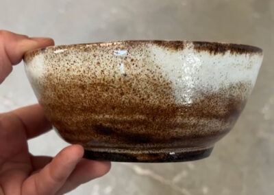 A small ceramic bowl, viewed from the side. May be wood fired.