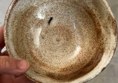 A small ceramic bowl, viewed from the top. May be wood fired.